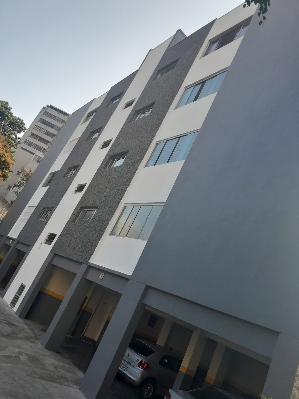 Prédio residencial com a fachada pintada em cinza e branco